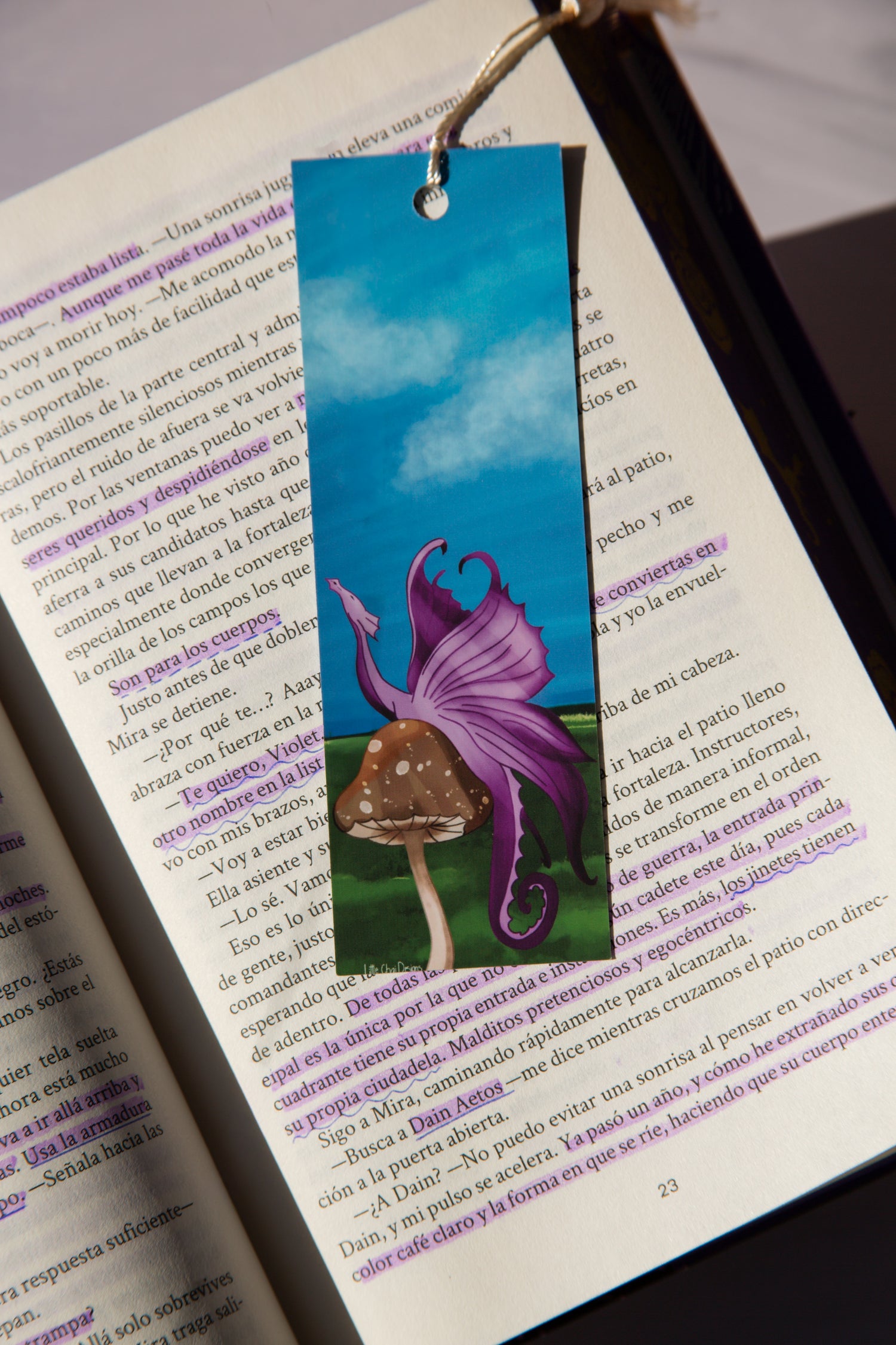 Bookmark with fairy and mushroom design on an open book