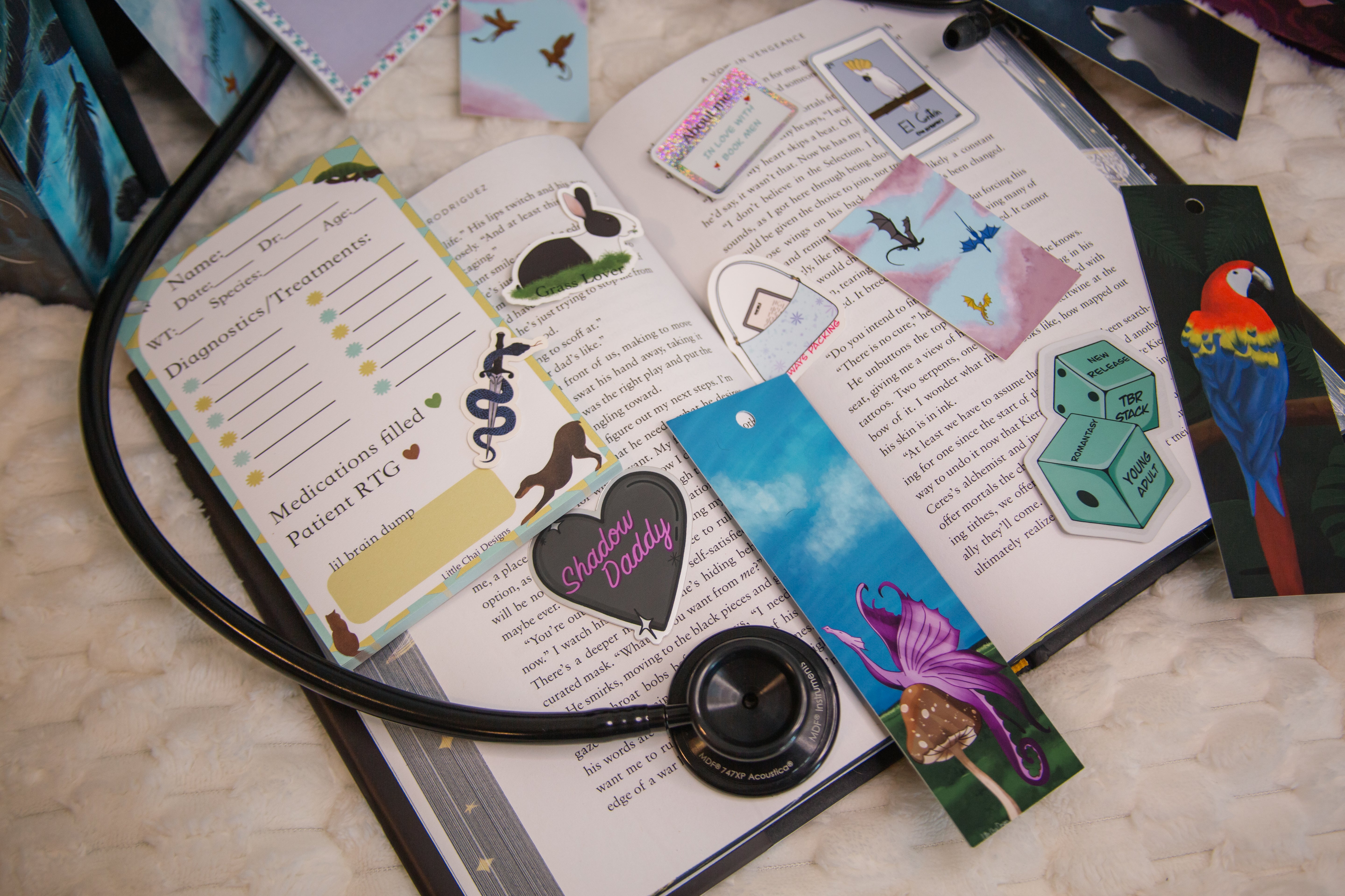 Open book with bookmarks and decorative cards on a textured surface